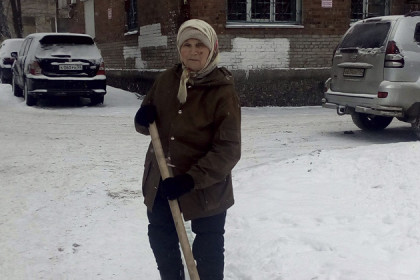  86-летняя женщина помогает дворникам чистить снег