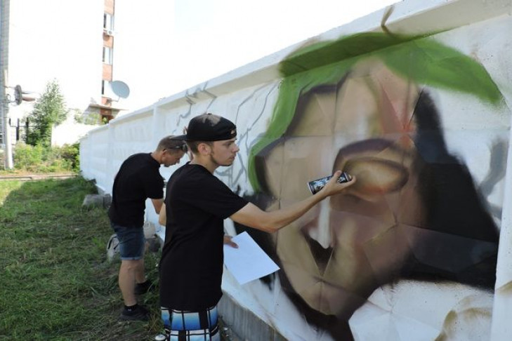 Граффити-художники разрисовывали забор кондитерской фабрики в Искитиме